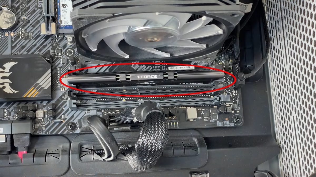 Tira de memoria RAM DDR4 insertada verticalmente en una ranura de placa base en un PC fijo